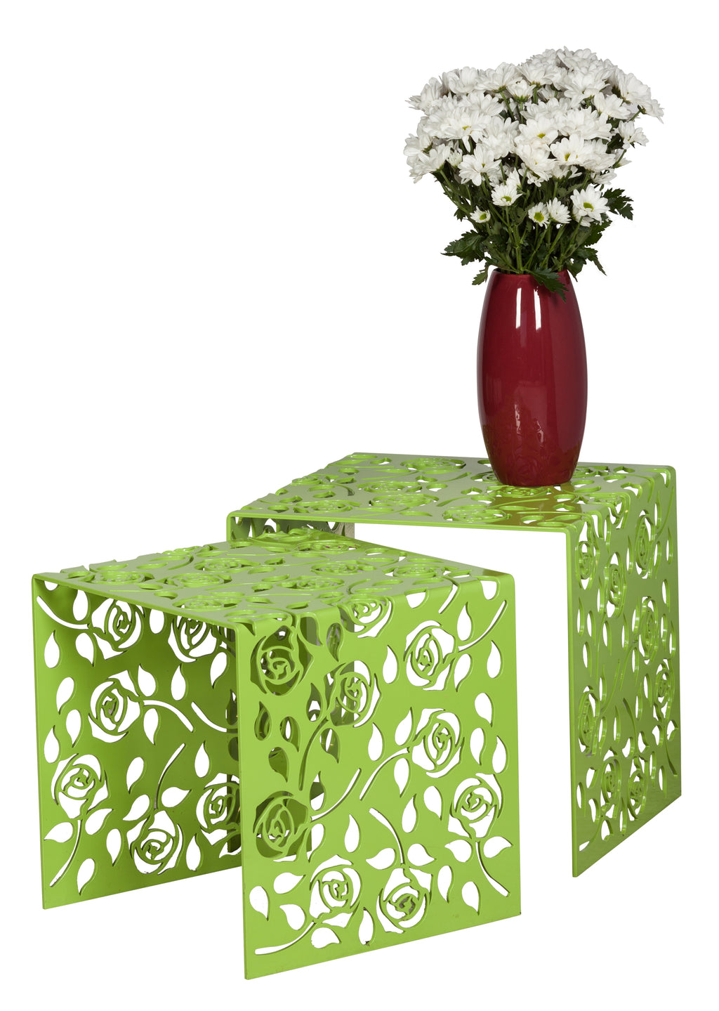 Two green metal side tables with floral cut-out designs and a red vase with white flowers on a white background.